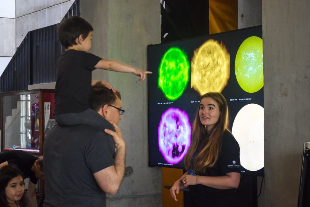 father and son learning from astro grad student